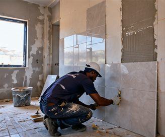 A tiler laying wall tiles